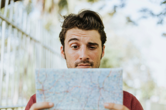 Confused man looking at map